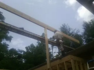 Carpenter setting a ridge beam over a new addition frame — Ice Dam Removal by Roofing Brothers in Carnation