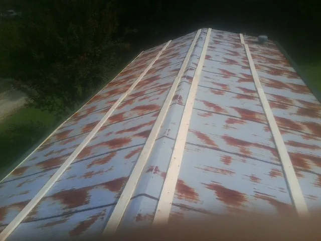 Rusted metal roof panels with new wood purlins before replacement — Storm Damage Roof Repair in Carnation by Roofing Brothers
