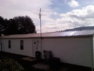 New metal roof on a single wide mobile home with a TV antenna in Carnation