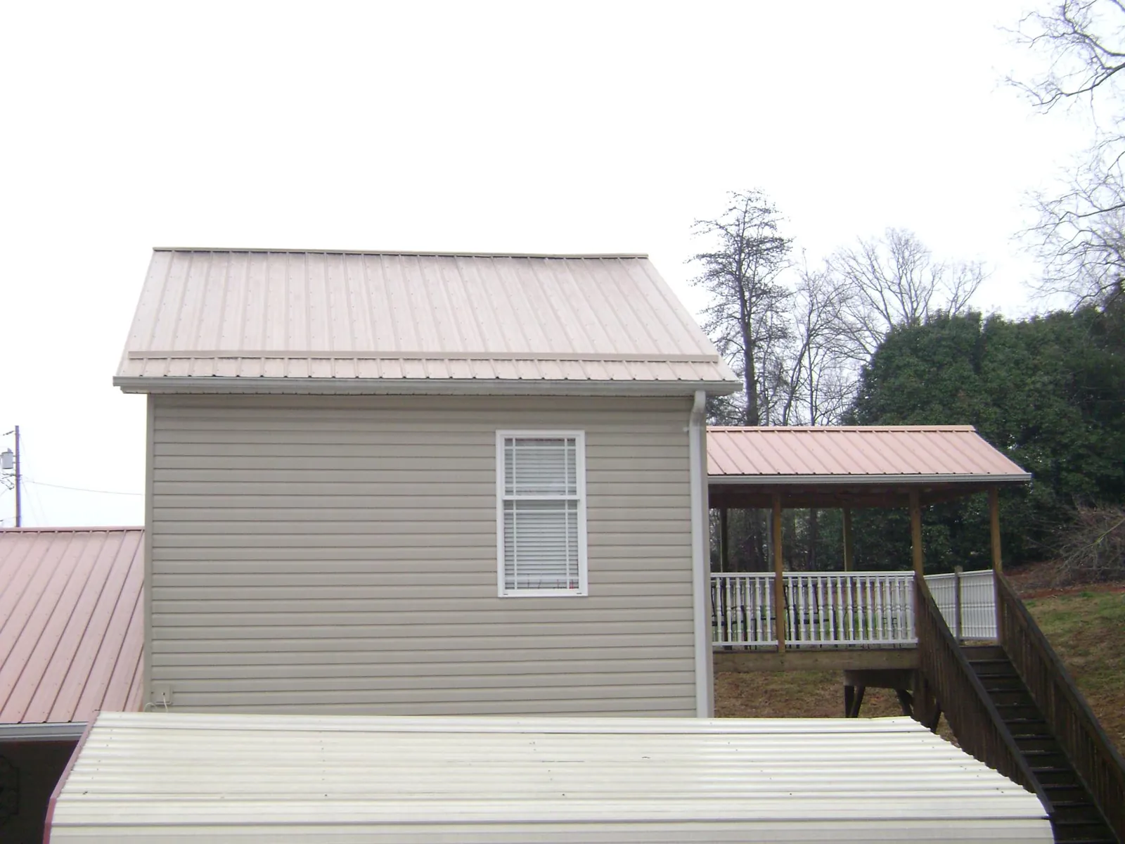 Tan metal roofs on a two story addition and attached porch, from a Roof Replacement job in Carnation